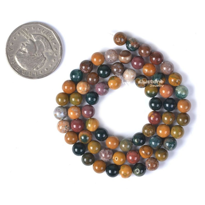 Pu&ograve; includere: Una collana di perline rotonde in diaspro multicolore. Le perline hanno un diametro di circa 8 mm e hanno una finitura lucida. I colori delle perline includono marrone, giallo, verde e rosso.