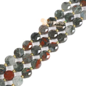 May include: A strand of round, faceted gemstone beads in shades of green, red, and black. The beads are strung on a gold wire with green spacers.