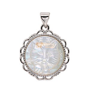 May include: A silver-toned pendant with a cat design. The pendant features a round, iridescent mother-of-pearl center with a detailed cat face. The pendant has a decorative, scalloped edge and a bail for a chain.