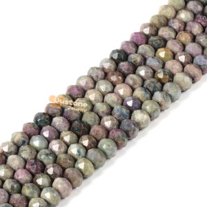 May include: A strand of faceted gemstone beads in shades of green, blue, and purple. The beads are round and have a slightly irregular shape.