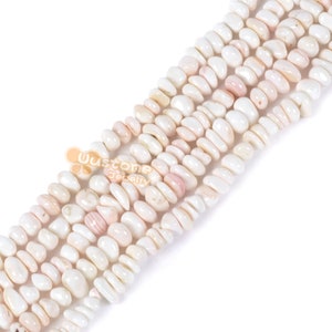 May include: A strand of white and pink shell beads. The beads are oval shaped and have a smooth, polished finish.