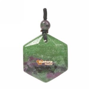 Può includere: Ciondolo esagonale verde e rosa con un cordoncino nero e una piccola perla verde e rosa in cima. Il ciondolo ha una finitura lucida e lucidata. Il ciondolo è etichettato "Uustone Jewelry".