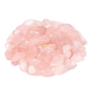 May include: A pile of pink rose quartz tumbled stones. The stones are smooth and polished, with a light pink colour.