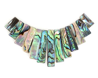May include: A necklace made of iridescent abalone shell pieces in shades of green, blue, and brown. The pieces are arranged in a fan shape, with the largest piece at the top and the smallest piece at the bottom.