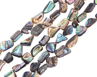 Peut inclure: Un brin de perles d'ormeau irisées, chaque perle est de forme irrégulière et unique, avec un mélange de couleurs brunes, vertes et bleues.