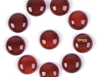 May include: Ten round, red cabochon gemstones arranged in a circle on a white background.