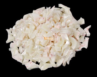May include: A pile of white and pink iridescent shell pieces. The shell pieces are irregular in shape and size.