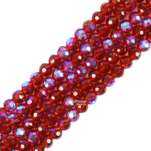 May include: A strand of red faceted glass beads with iridescent shimmer. The beads are round and have a smooth, polished finish.