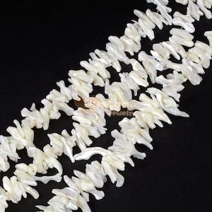 May include: A strand of white, irregularly shaped, mother of pearl beads. The beads are arranged in a staggered pattern, creating a flowing, organic look.