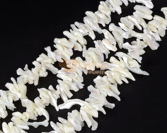 May include: A strand of white, irregular shaped, mother of pearl beads. The beads are arranged in a staggered pattern, creating a flowing, organic look.