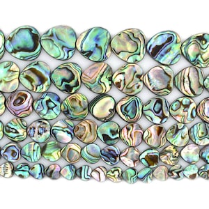 May include: A collection of iridescent abalone shell heart-shaped beads in various shades of green, blue, and brown. The beads are arranged in rows, creating a visually appealing pattern.