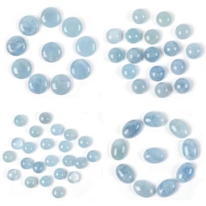 Könnte beinhalten: Eine Sammlung von hellblauen Edelstein-Cabochons in verschiedenen Größen und Formen. Die Cabochons sind in verschiedenen Mustern auf weißem Hintergrund angeordnet.