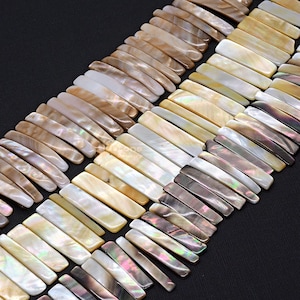 以下が含まれることがあります： 茶色、白、グレーの虹色の、平らな長方形の貝殻ビーズのストランド。ビーズは交互に配置され、視覚的に魅力的なテクスチャを生み出しています。