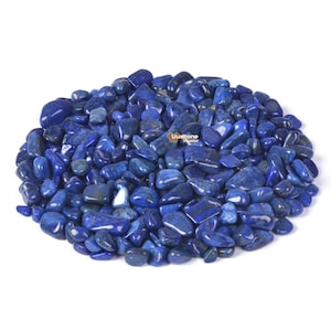 Puede incluir: Un montón de piedras de lapislázuli pulidas, de color azul intenso. Las piedras varían en tamaño y forma, con una superficie lisa y reflectante. La imagen está bien iluminada, resaltando el rico color y la textura de las piedras preciosas. El texto "uustone jewelry" es visible.
