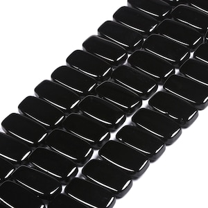 May include: A collection of smooth, polished black beads arranged in multiple parallel rows. Each bead features a rectangular shape with rounded corners and a glossy, reflective surface, creating a uniform and consistent appearance throughout.