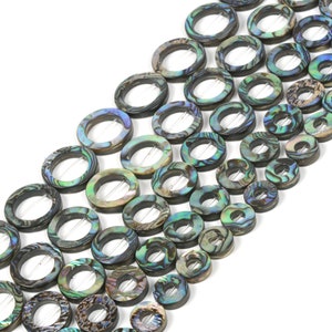 May include: A strand of iridescent abalone shell beads in a variety of sizes. The beads are round with a hole in the center and have a natural, organic look.