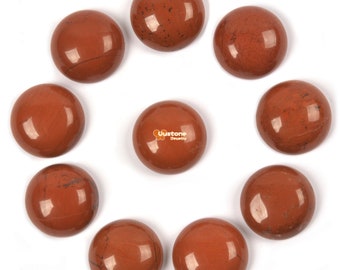 May include: Ten round, red, polished, gemstone cabochons arranged in a circle on a white background.