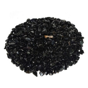 May include: A large pile of black obsidian chips. The chips are smooth and polished, and they have a dark, almost black color.