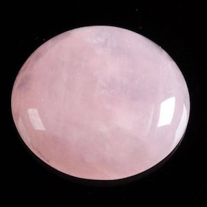 May include: A smooth, oval-shaped rose quartz crystal with a pale pink colour. The crystal is polished and has a glossy finish.