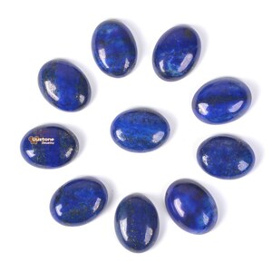 May include: Ten oval-shaped lapis lazuli gemstones with a deep blue colour and gold flecks. The stones are arranged in a circle on a white background.