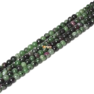 May include: A strand of green, black, and pink round gemstone beads. The beads are approximately 6mm in diameter and have a smooth, polished finish.