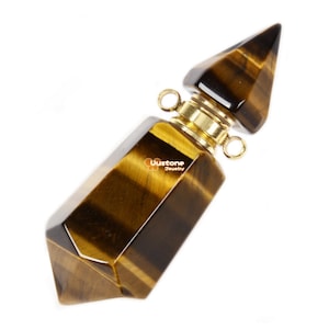 Puede incluir: Un colgante de cristal de ojo de tigre con tapa dorada, punta puntiaguda y cuerpo facetado. El colgante está diseñado para contener aceites esenciales o perfumes.
