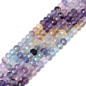 May include: A strand of faceted fluorite beads in shades of blue, purple, and yellow. The beads are arranged in a gradient pattern, with the lightest shades at one end and the darkest shades at the other.