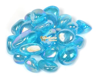May include: A pile of iridescent blue tumbled stones. The stones are smooth and have a light blue color with a rainbow sheen.