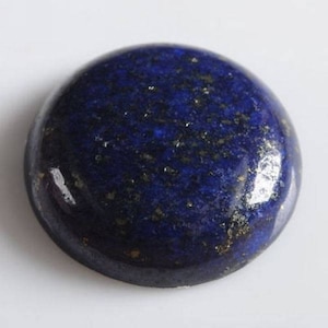 May include: A round, polished lapis lazuli cabochon with a deep blue color and gold flecks.