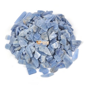 Könnte beinhalten: Ein Haufen hellblauer Kyanit-Edelsteinchipse. Die Chips sind unregelmäßig geformt und haben eine glatte, polierte Oberfläche.