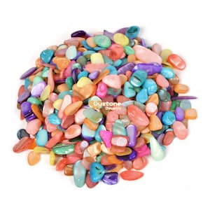 May include: A pile of colorful, iridescent, and smooth, flat, oval-shaped seashells. The shells are in various shades of pink, blue, green, orange, and purple.
