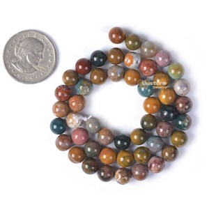 Pu&ograve; includere: Una collana di perline rotonde in pietra naturale multicolore. Le perline sono un mix di marrone, verde, giallo e rosso con macchie bianche. Le perline hanno un diametro di circa 8 mm.