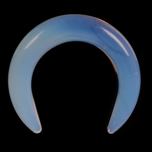 May include: A light blue opal horseshoe shaped ring.