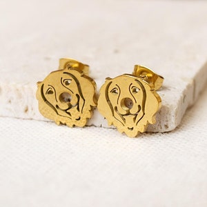 Könnte beinhalten: Ein Paar goldfarbene Ohrringe aus Edelstahl mit einem ausgeschnittenen Design eines Hundekopfes.