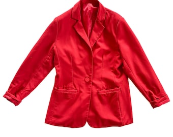 May include: A bright red blazer with a single-button closure and two front pockets. The jacket has long sleeves and a classic lapel collar. The blazer is a solid color and appears to be made of a smooth fabric.