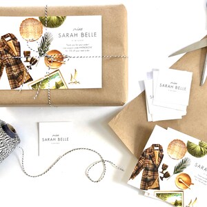 May include: A brown paper package tied with twine and a white and black patterned string. The package has a white gift tag with the text "miss sarah belle vintage" and a watercolor illustration of a plaid jacket, a woven basket, a potted plant, and a vintage postcard.