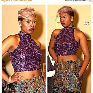 May include: A woman wearing a purple sequined halter top and patterned pants. She is also wearing a matching headpiece with a veil. The outfit is a mix of textures and patterns, creating a bold fashion statement.