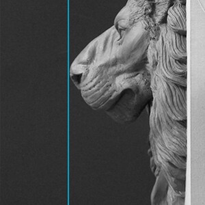 Pode incluir: Escultura a preto e branco da cabe&ccedil;a de um le&atilde;o em perfil, com aproximadamente 10 cm de altura. A juba do le&atilde;o &eacute; detalhada com linhas fluidas, e a escultura est&aacute; sobre um fundo escuro.