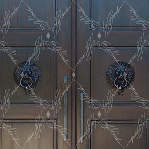 Pode incluir: Portas duplas castanhas escuras com aldravas ornamentadas em forma de cabe&ccedil;a de le&atilde;o. As aldravas s&atilde;o feitas de metal escuro e apresentam um anel para bater. As portas t&ecirc;m pain&eacute;is verticais e puxadores longos e finos.