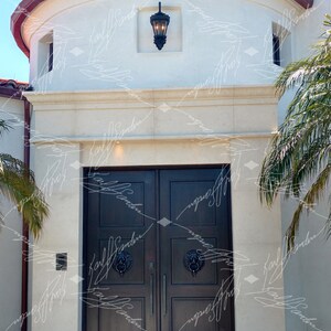 Pode incluir: Vista exterior de um edif&iacute;cio com uma entrada de porta dupla castanha escura. A porta tem aldravas com cabe&ccedil;a de le&atilde;o. Acima da porta, h&aacute; uma fachada de pedra de cor clara. O telhado tem telhas vermelhas. Uma lanterna preta est&aacute; pendurada acima da porta.