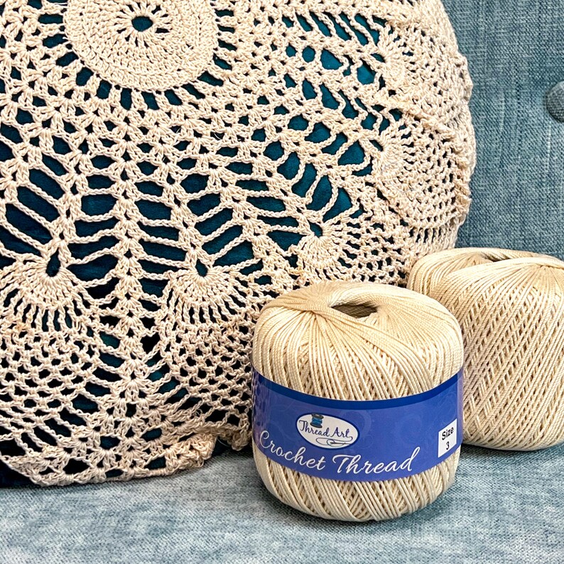 two balls of yarn sitting next to a crochet bag