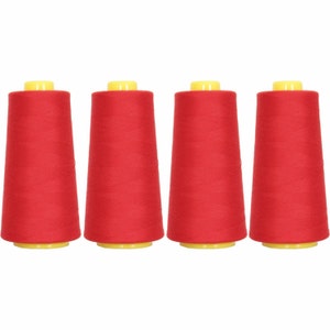 May include: Four spools of red thread, each with a yellow plastic top.
