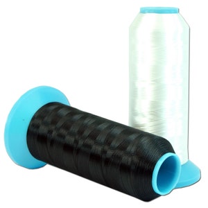May include: Two spools of thread, one black and one white, with blue plastic bobbins. The spools are made of a clear plastic material and are wound with thread.