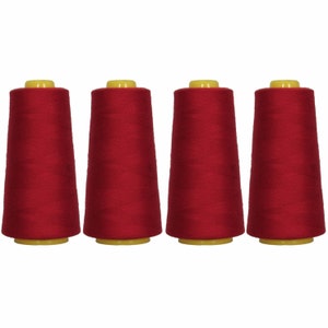 May include: Four spools of red thread, each with a yellow plastic top.