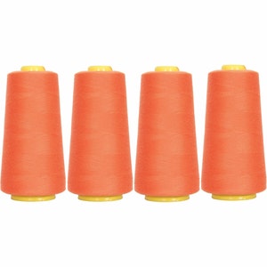May include: Four spools of orange thread, each with a yellow plastic top.