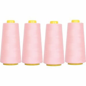 May include: Four spools of pink thread with yellow tops.