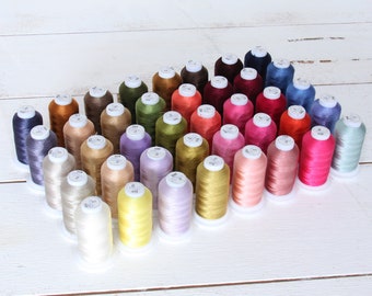 May include: A collection of 40 spools of embroidery thread in various colors, arranged in a triangular pattern. The spools are labeled with numbers.