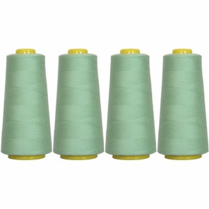 May include: Four spools of light green sewing thread with yellow tops.
