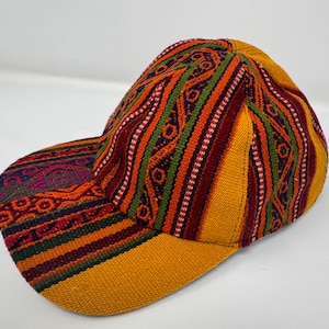 Puede incluir: Gorra de béisbol colorida con un diseño estampado. La gorra presenta una visera amarilla y una corona con rayas verticales en rojo, naranja, verde y blanco. Hecha de tela tejida.