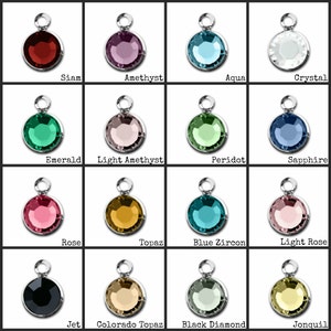 May include: Assortment of 16 different colored round glass beads with silver metal caps. The beads are arranged in a grid of four rows and four columns. The colors include red, purple, blue, white, green, pink, yellow, and black.